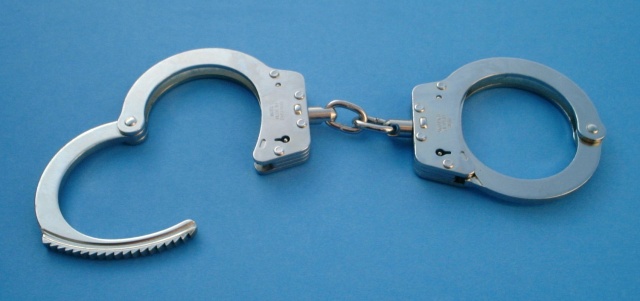 Handcuffs on a nondescript blue background.