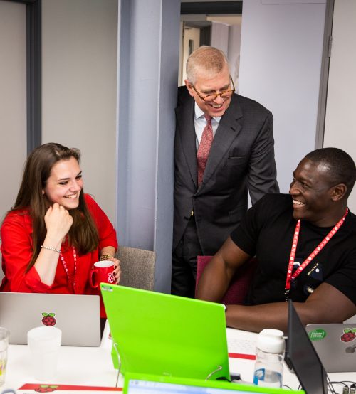 Prince Andrew speaking to two seated people