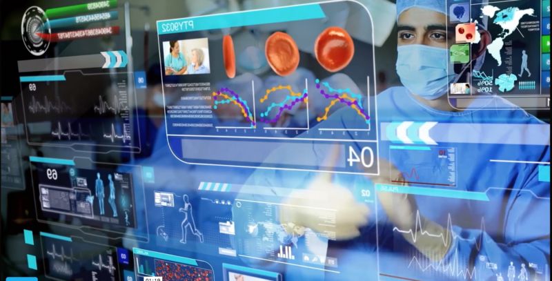 A man in surgical garb inspects a cutting-edge computer display.