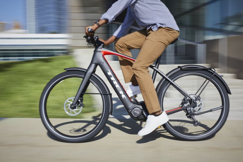 Promotional image of a man in business casual riding a bicycle.