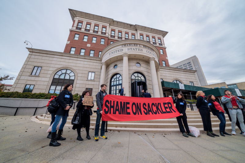 Protesters hold up sign that says