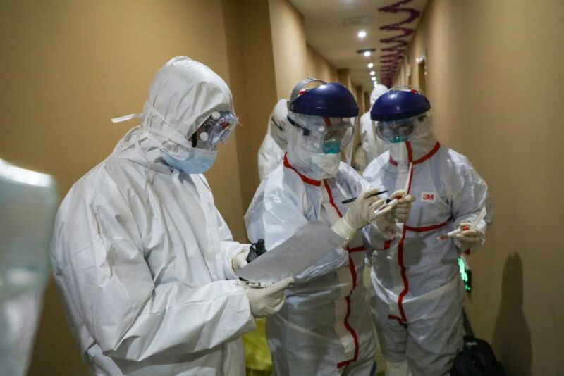 This photo taken on February 4, 2020 shows a medical staff member (C) marking a test tube containing samples taken from a person to be tested for the new coronavirus at a quarantine zone in Wuhan, the epicentre of the outbreak, in China's central Hubei province. 