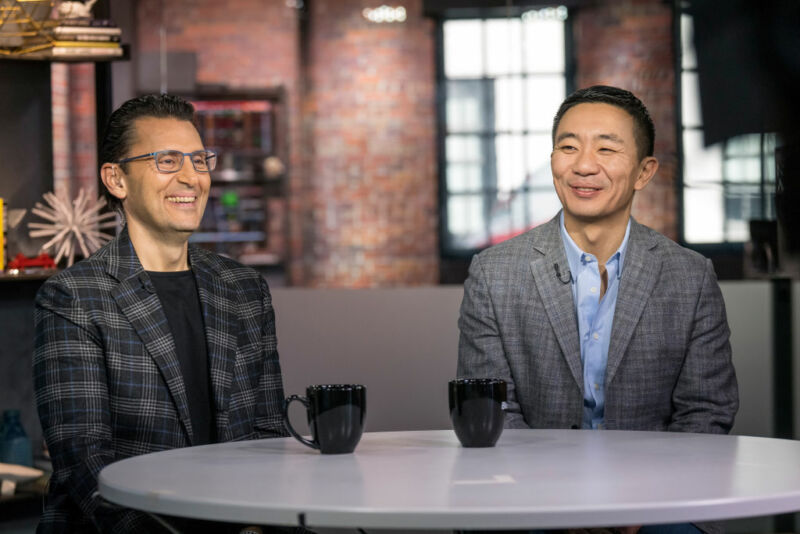 Two men share coffee and a laugh.