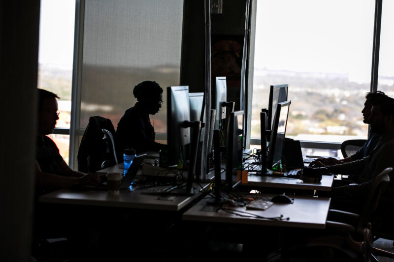 People work at computers in an open office.