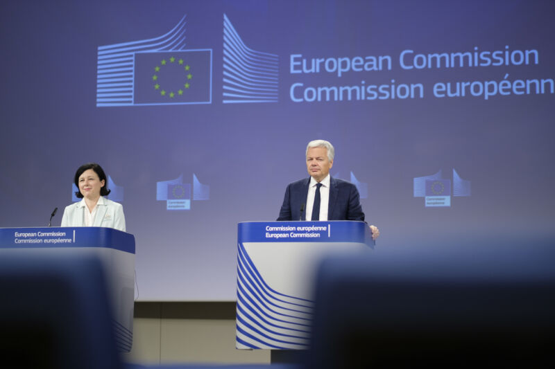 A man and a woman stand at podiums in front of an EU logo.