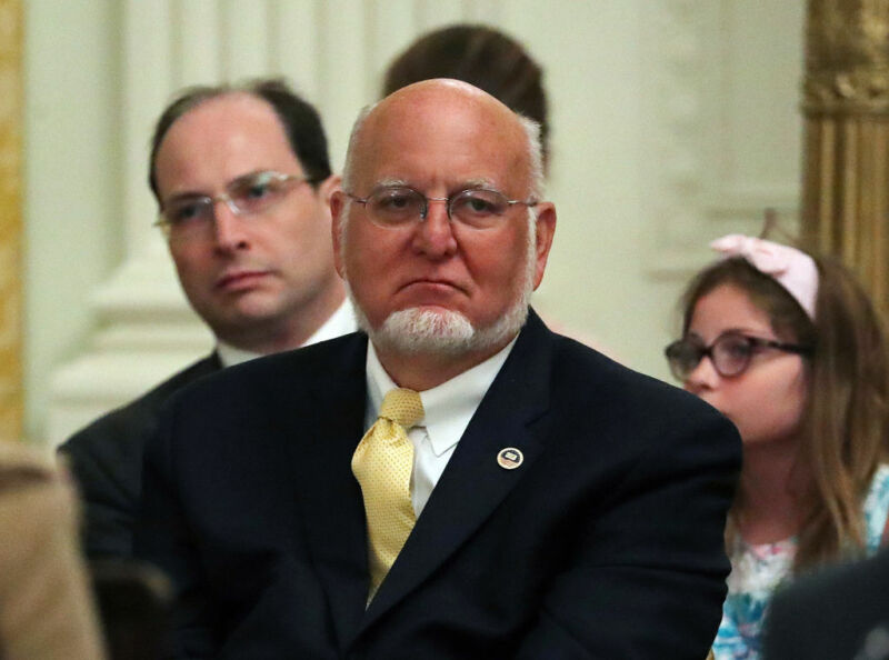 Image of a man in a suit with a yellow tie.