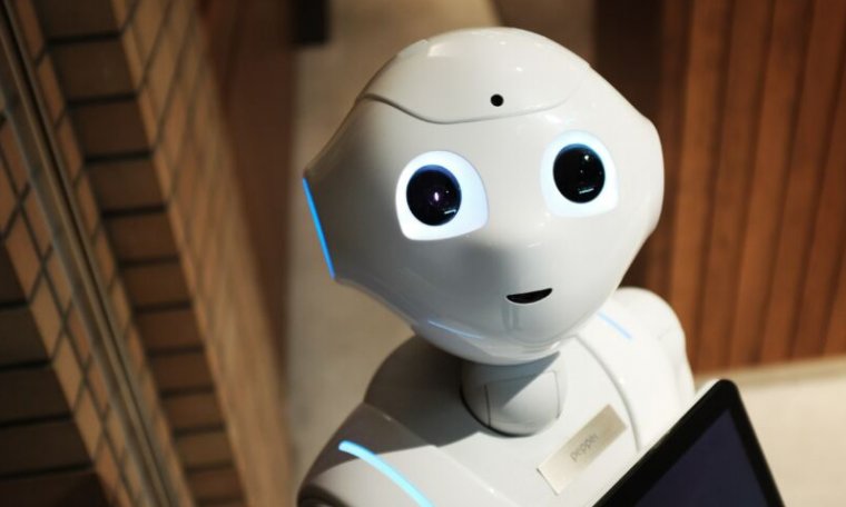 A smiling robot looks at the camera.