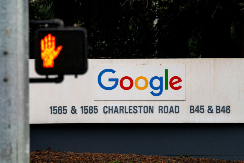 A traffic signal in front of Google HQ indicates that pedestrians should not walk.