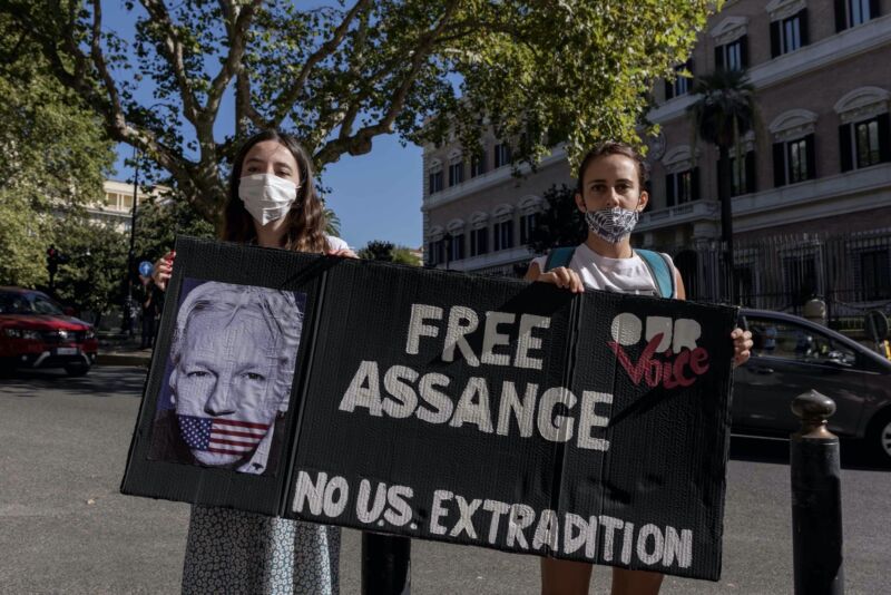 Two protesters hold up a sign that says