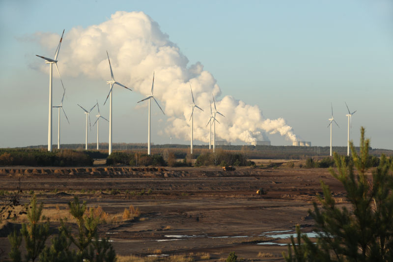 Wind turbines near a coal plant.