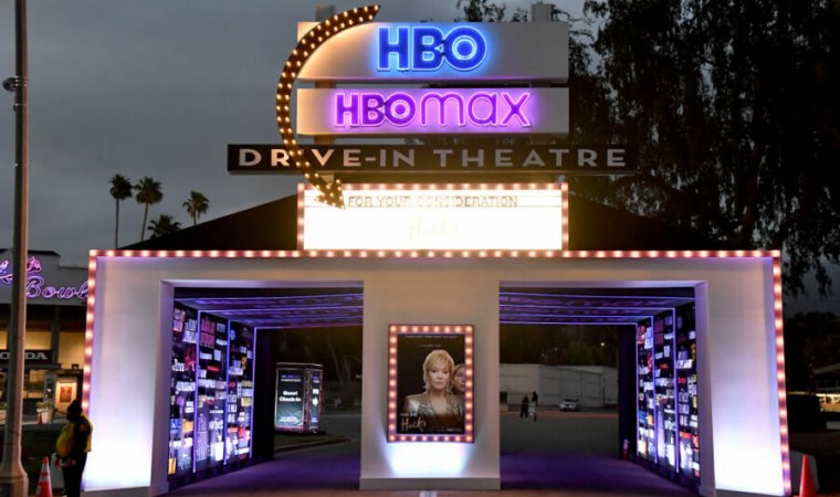 The entrance to a drive-in theater has been manipulated to include promotional posters for current HBO offerings.