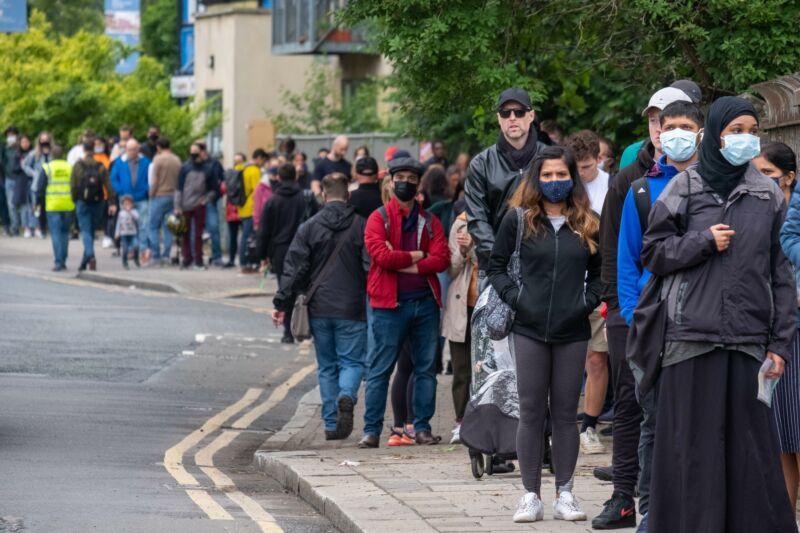 People line up outside Bridge Park Community Leisure Center to receive the COVID-19 vaccines in Brent, northwest London, June 19, 2021. A new wave of coronavirus infections is "definitely under way" in England due to the Delta variant first identified in India, a British government advisory scientist said Saturday.