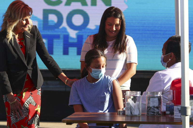 US first lady Jill Biden (L) comforts Adriana Lyttle, 12, as she receives her vaccine at a Covid-19 vaccination site at Ole Smoky Distillery in Nashville, Tennessee, June 22, 2021.