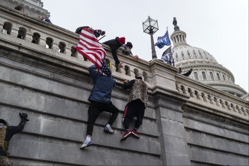 Trump supporters scaling the wall of the US Capitol building during the riot on January 6, 2021.