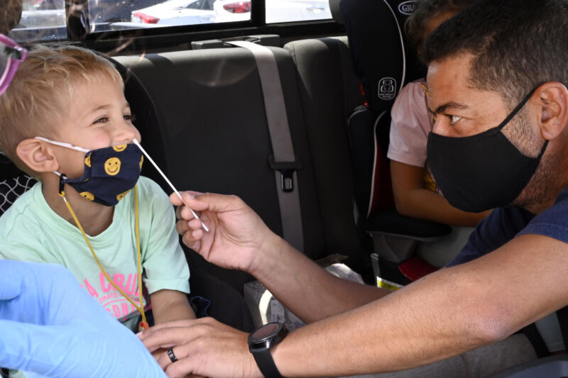 A kid gets a cotton swab shoved up his nose.