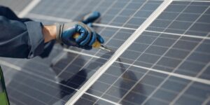 man-with-white-helmet-near-solar-panel