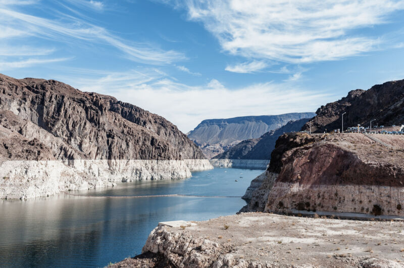 Image of a body of water between cliffs, with part of the cliff appearing white.