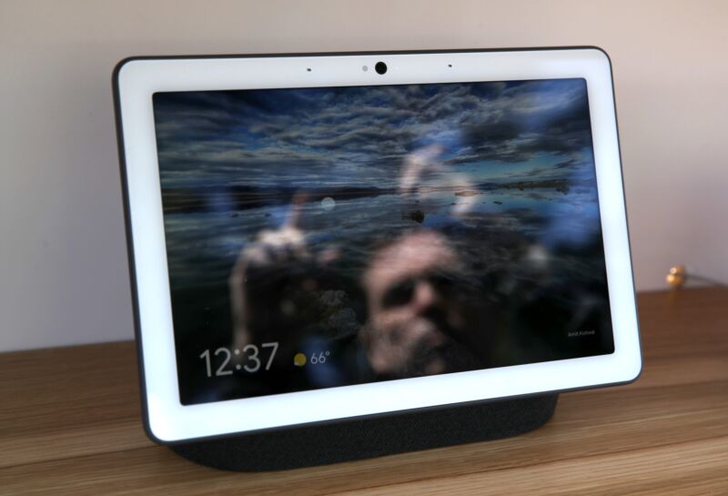 The Google Nest Hub Max smart home display, with a man's face reflected on the screen.