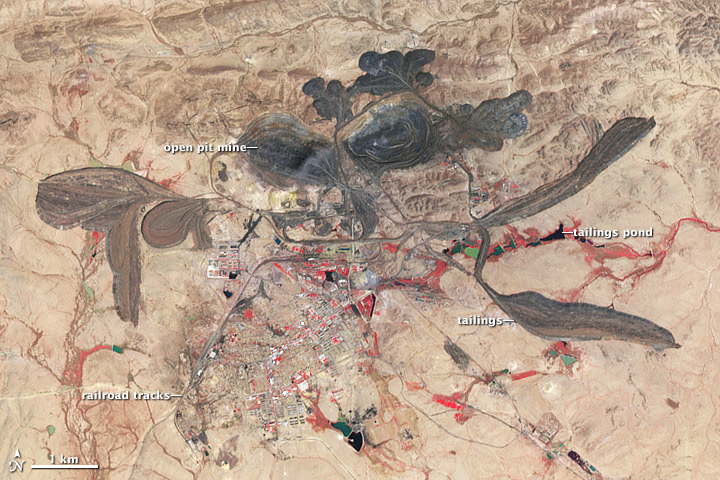 Labelled satellite image showing mine tailings and retention ponds in a desert environment.