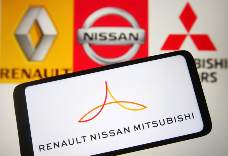 Renault, Nissan, and Mitsubishi logos behind a smartphone