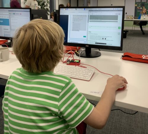 A child at a coding club with their code on screen in the Code Editor.