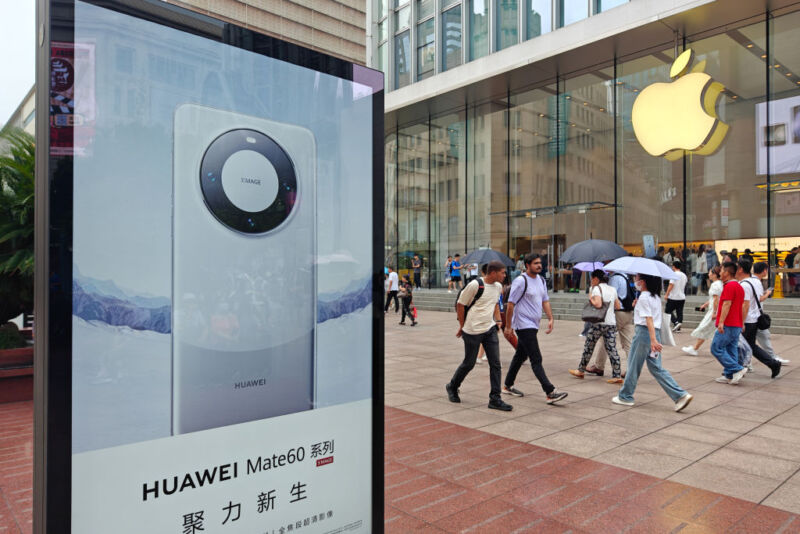 SHANGHAI, CHINA - SEPTEMBER 13, 2023 - A light box advertising Huawei Mate 60 mobile phone is seen in front of the Apple store on Nanjing Road in Shanghai, China, September 13, 2023.
