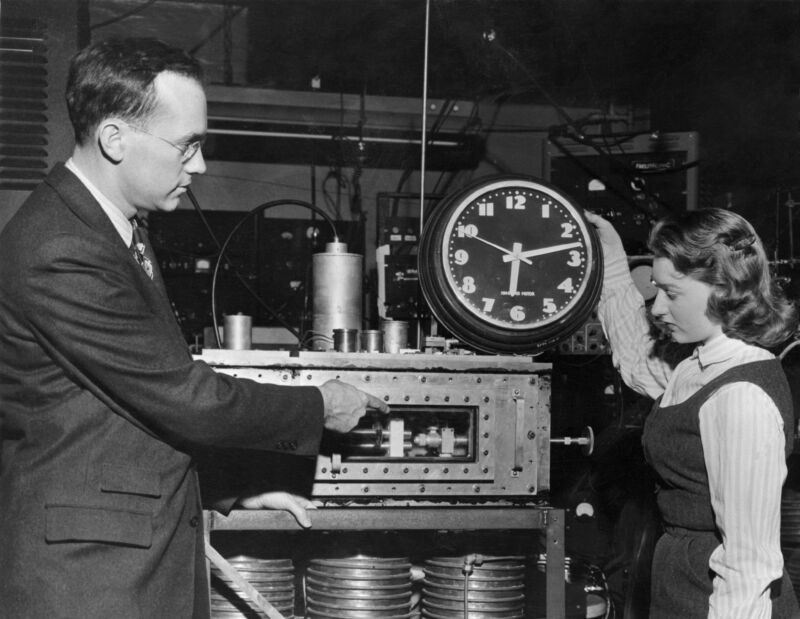 Dr. Charles H. Townes, inventor of the maser, a key component of atomic clocks, illustrates the differences between it and a standard clock.