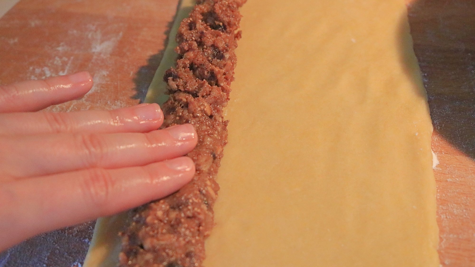 Hand putting filling on dough.