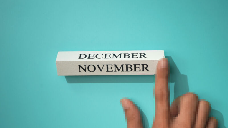 A hand moving a wooden calendar piece that says