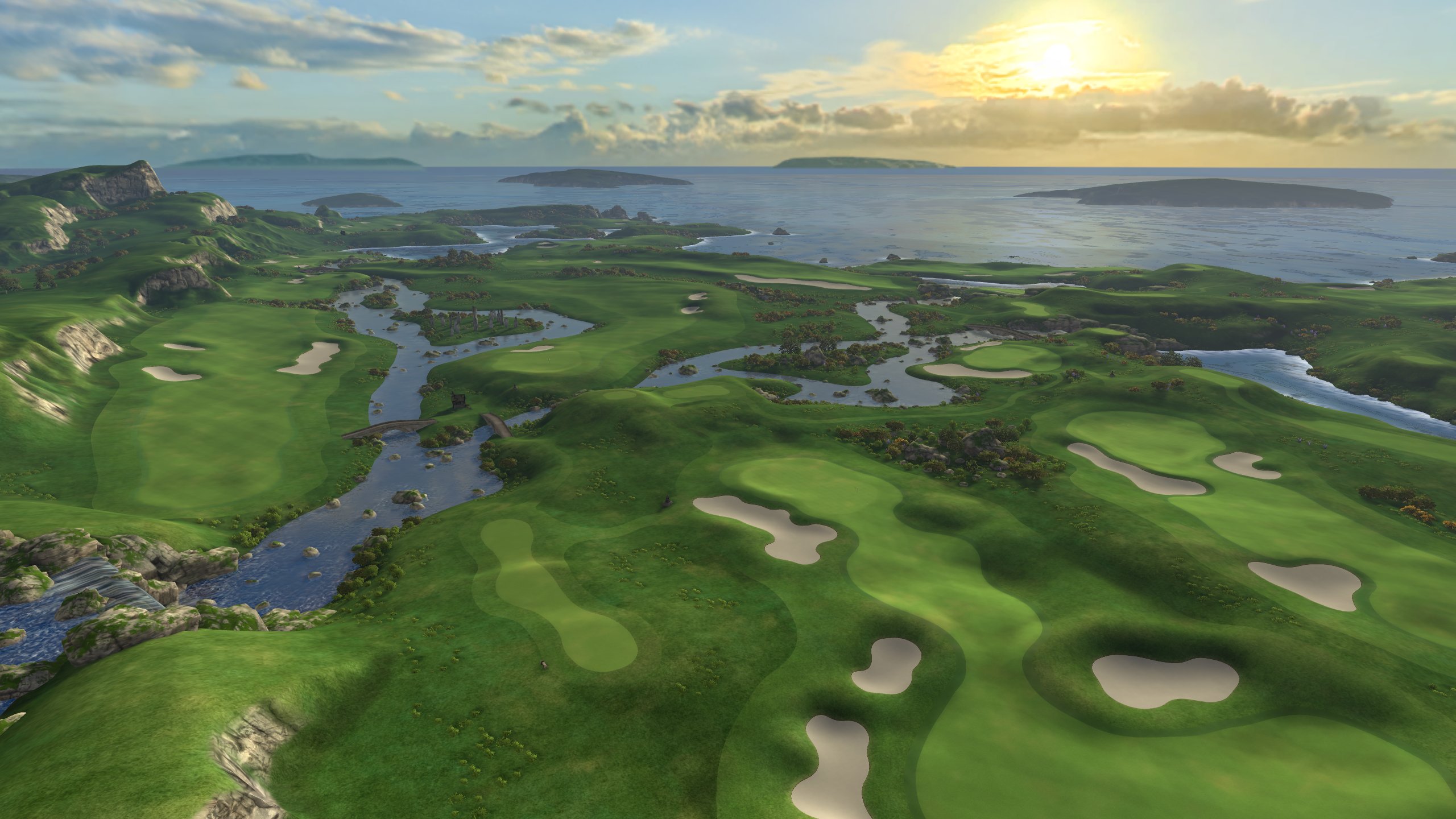 Aerial view of a coastal golf course in the VR game Golf+ with green fairways, sand bunkers and water hazards against a dramatic sea backdrop at sunset.
