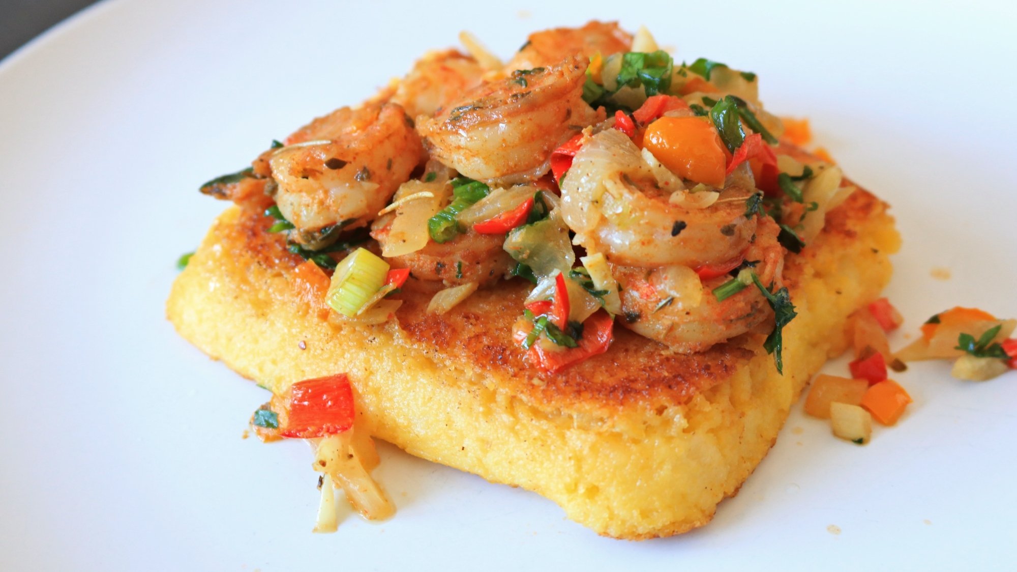Polenta with shrimp and veggies on top.