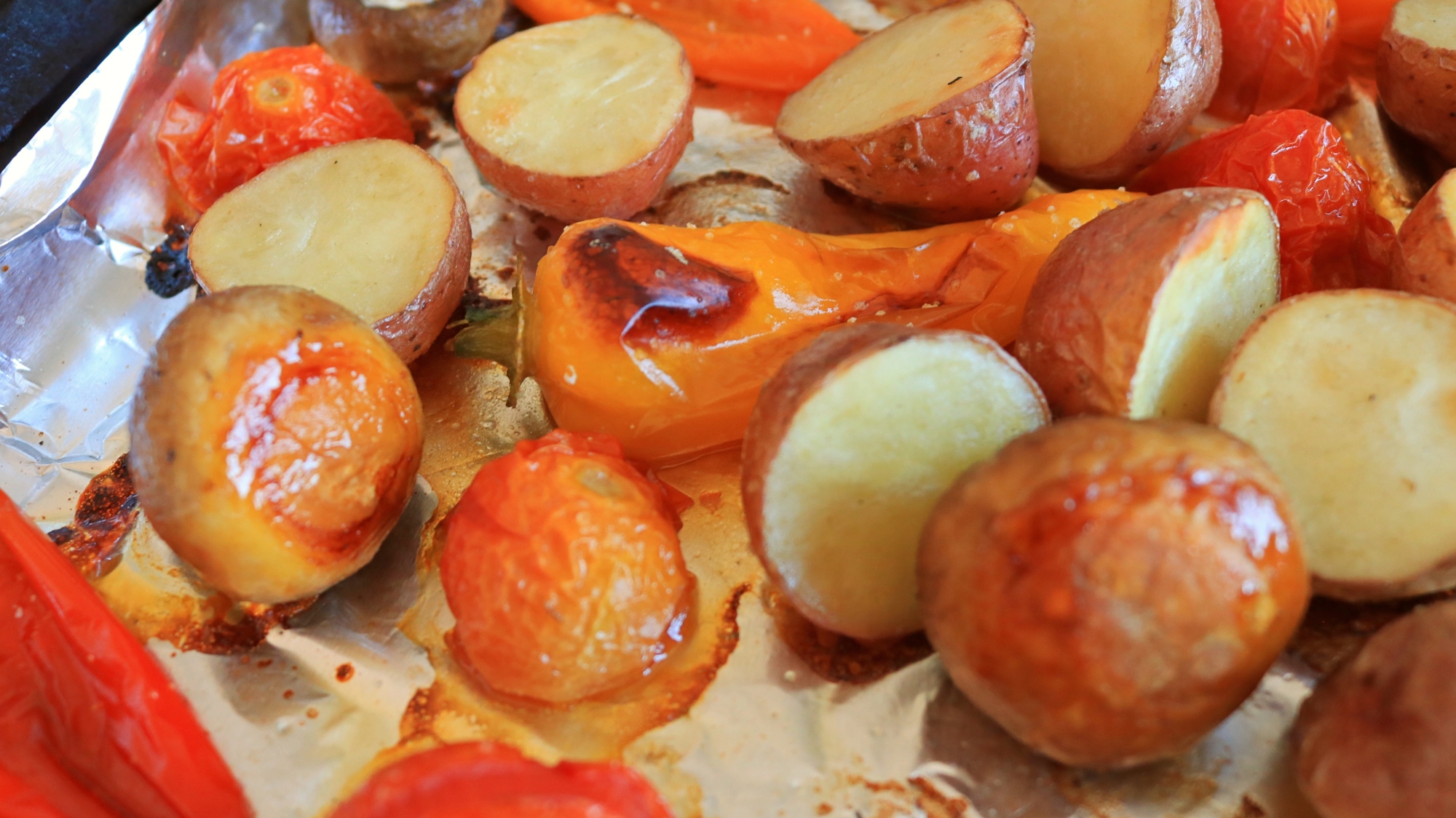 Roasted vegetables on a foil pan.