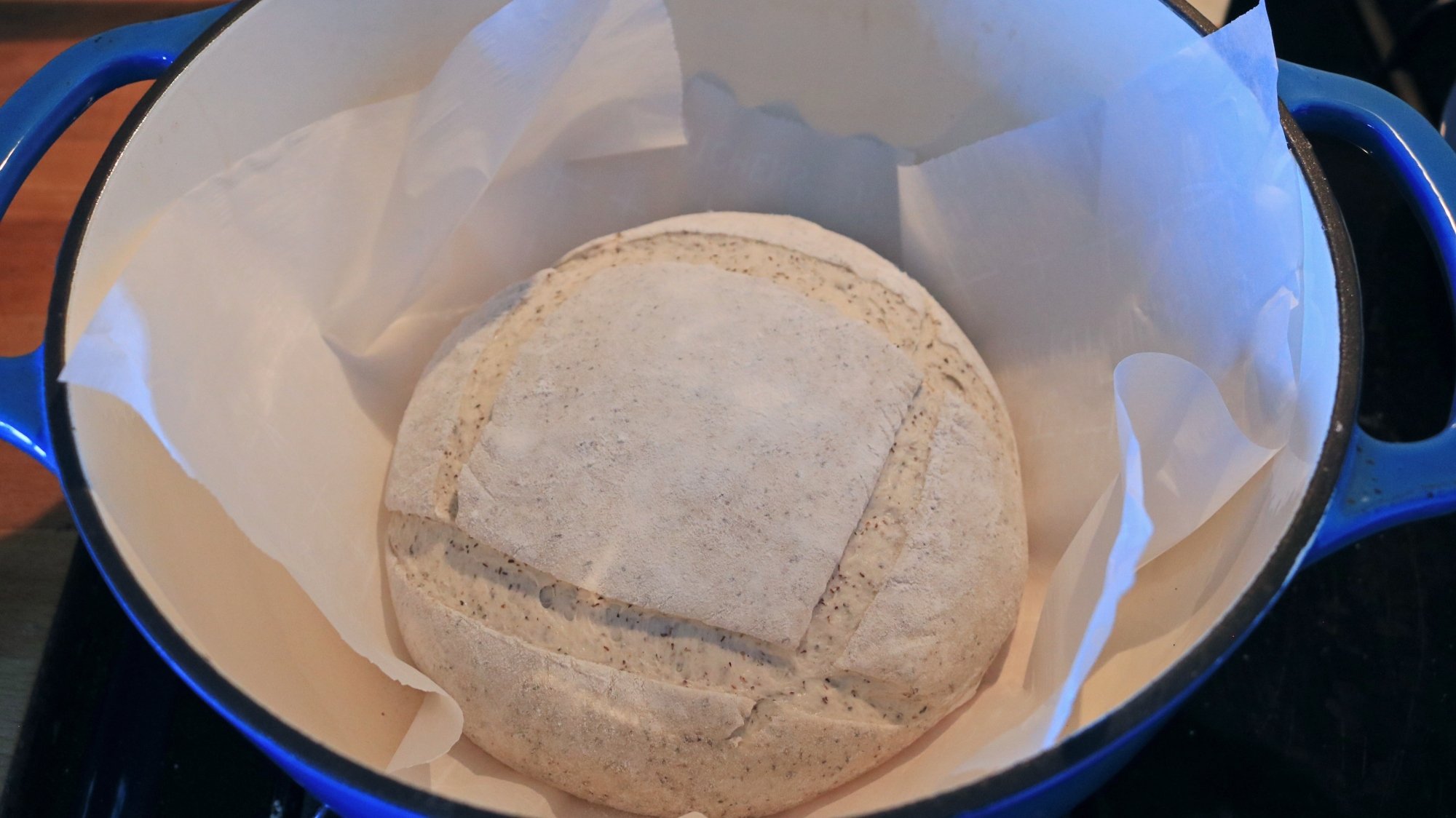 Raw bread dough loaf in a Dutch oven.