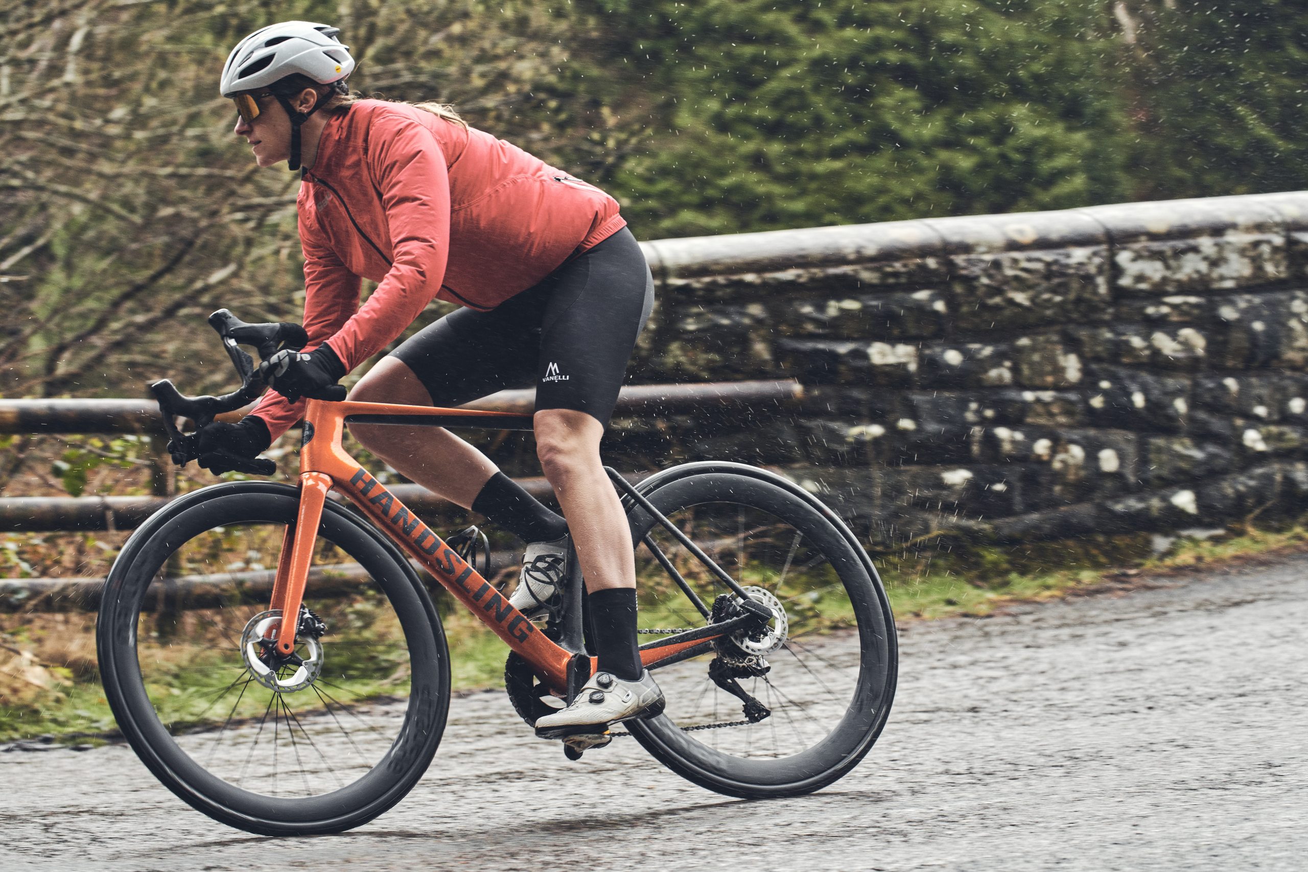 Female cyclist riding a road bike in wet weather