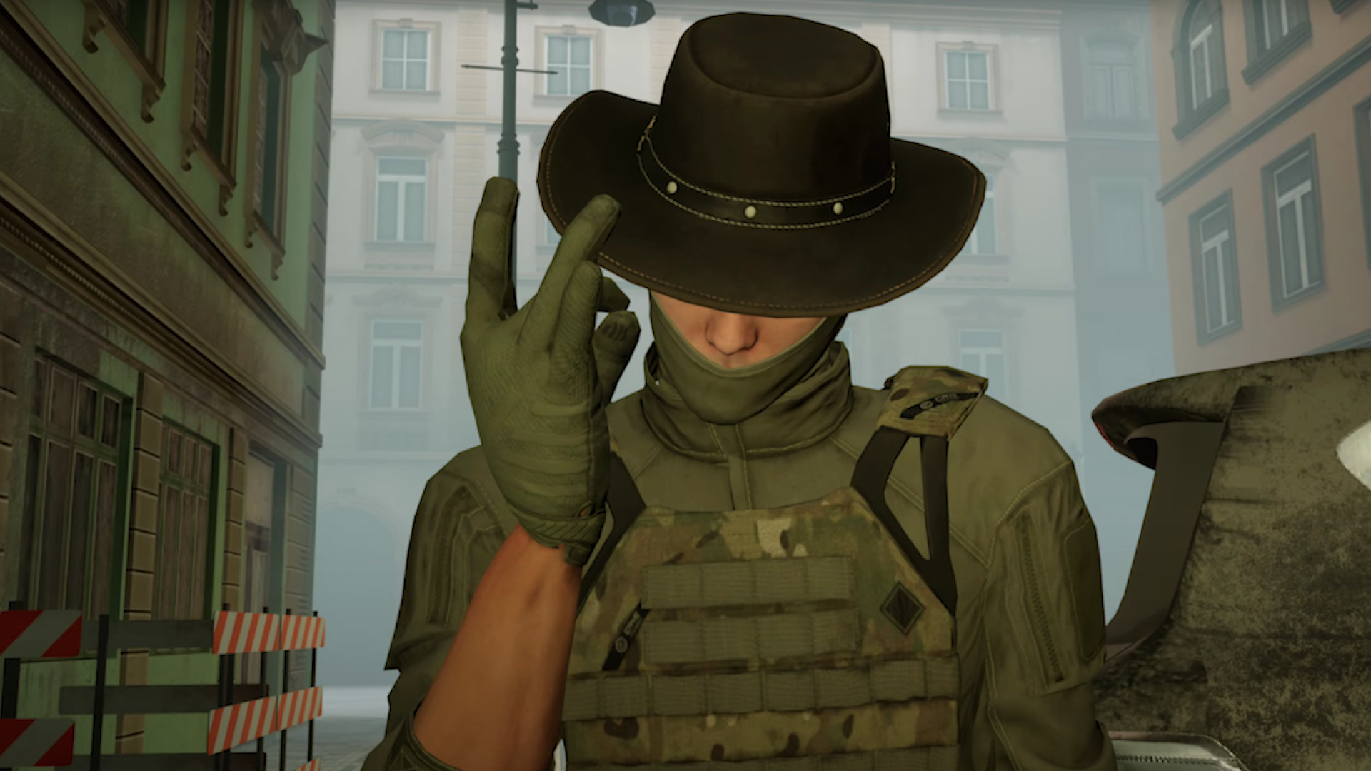 A soldier strokes the brim of his cowboy hat.