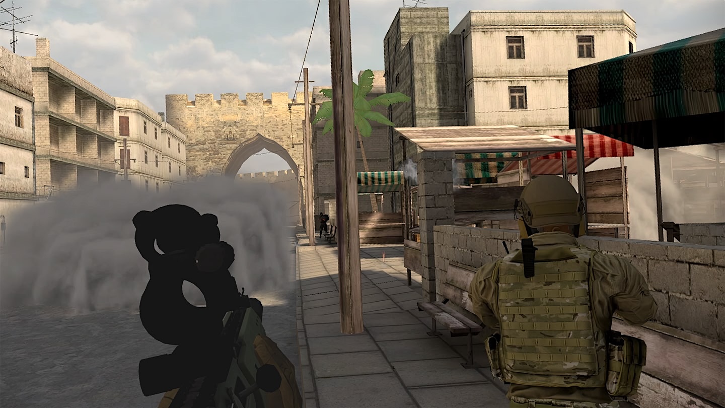 Two soldiers walk down a street as a cloud of dust approaches them.