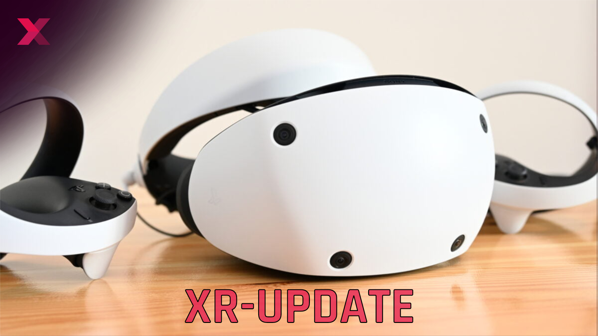 The white and black Sony Playstation VR 2 VR headset lies on a light brown wooden table with two VR controllers.