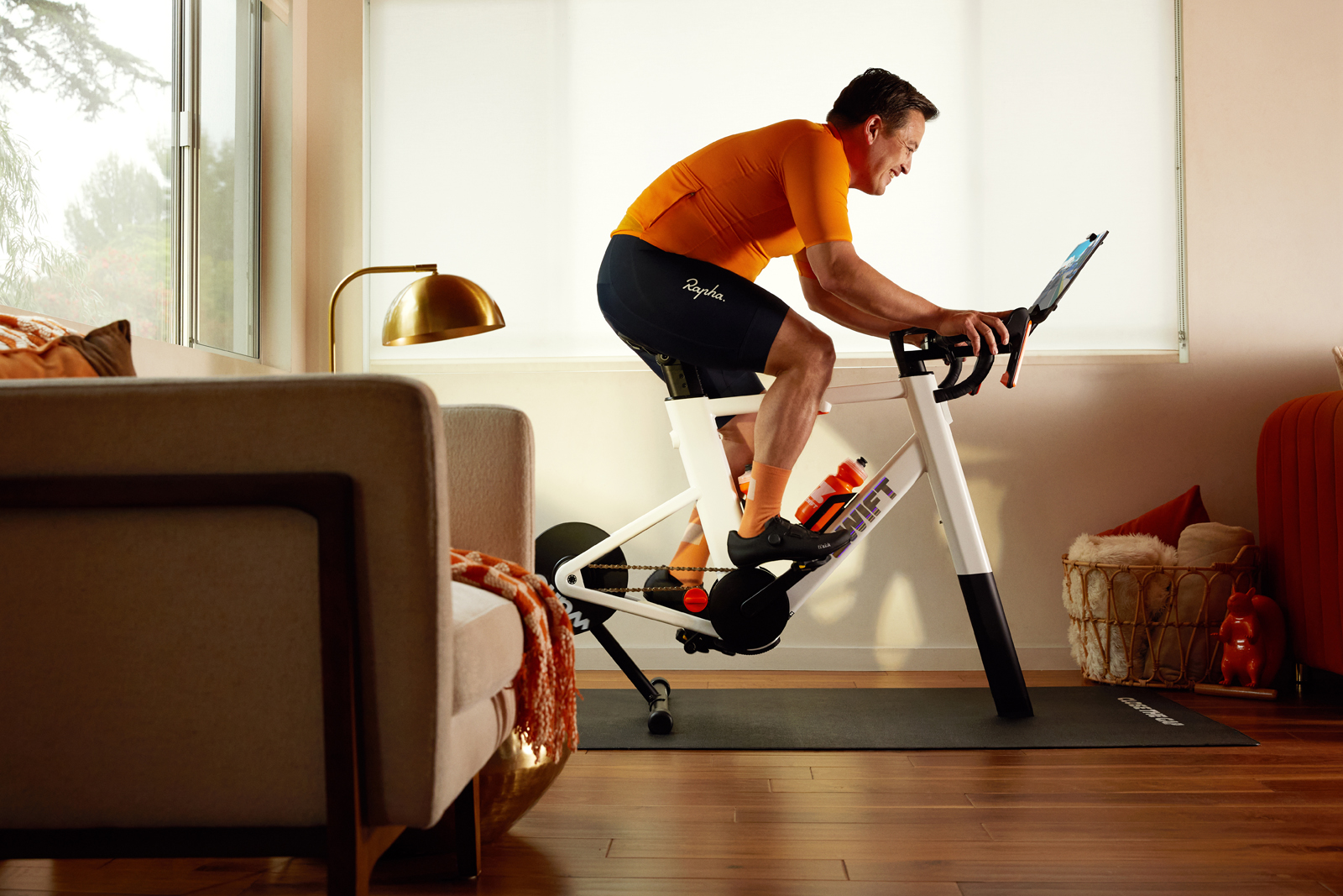 Man smiling and riding Zwift ride smart bike in home.