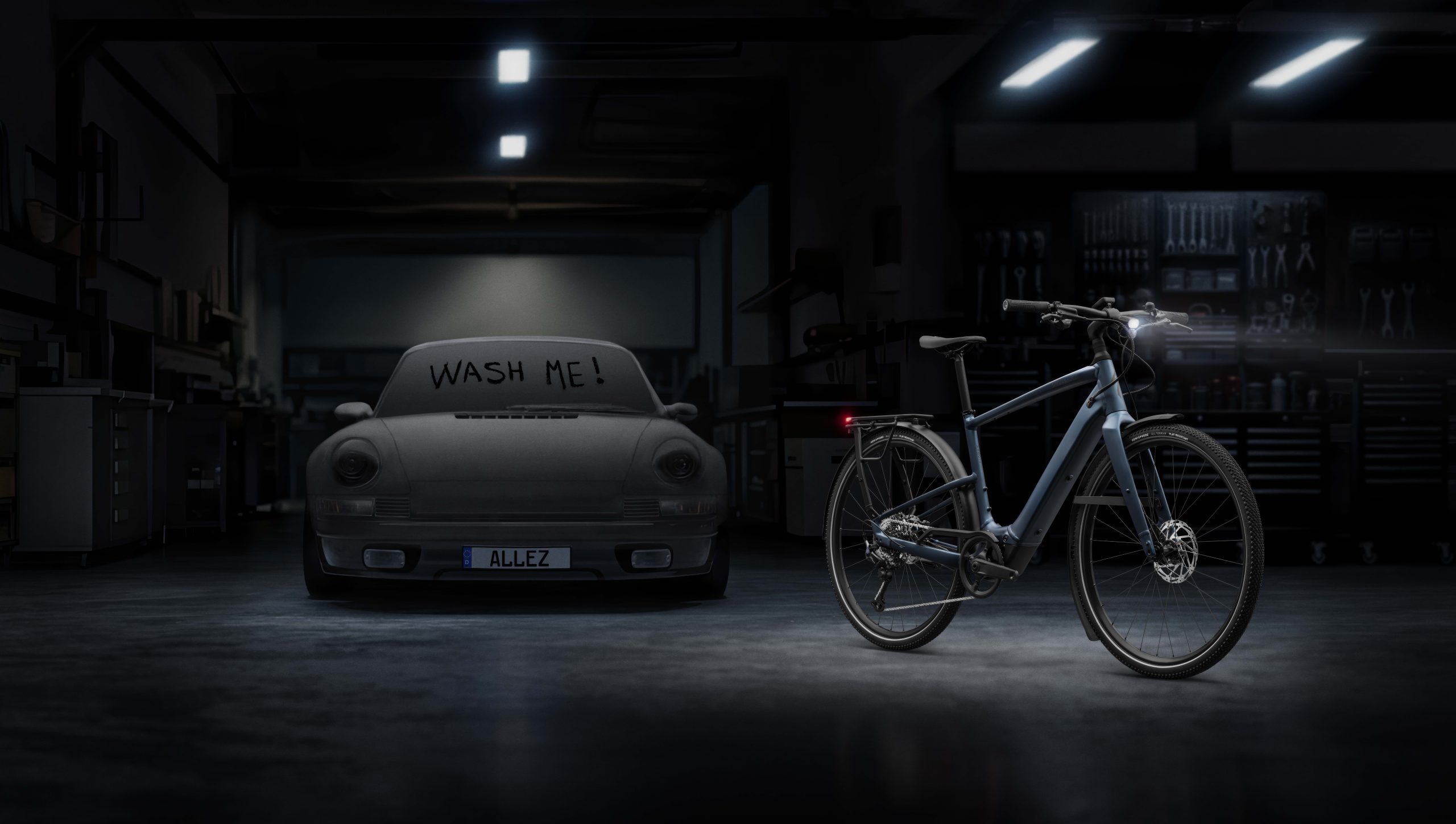 Specialized Vado SL 2 Alloy next to dirty car with 'wash me' written in dust on window.