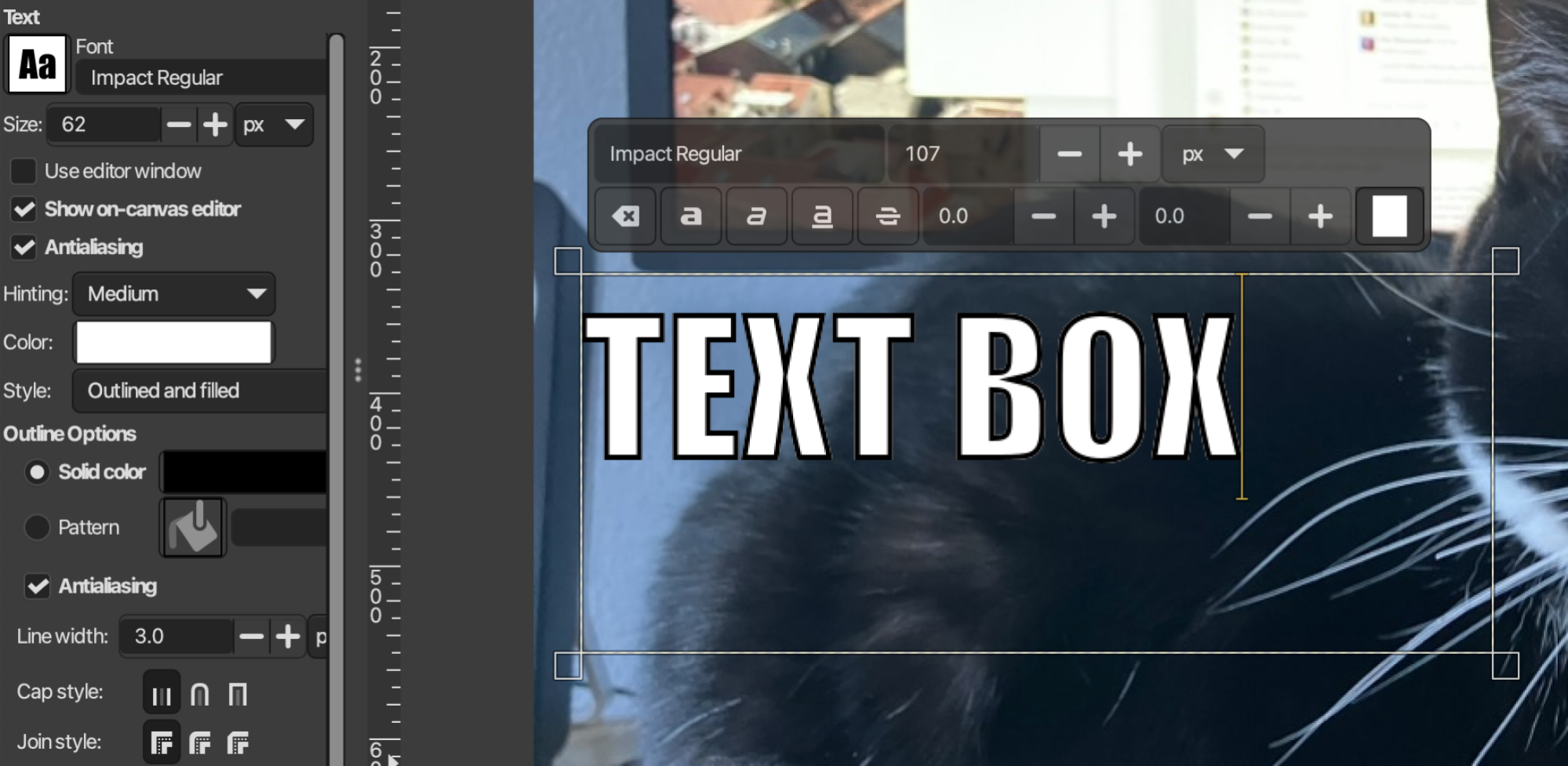 A text box, with the words "TEXT BOX" written in impact font, white with a black outline, all made using GIMP's new non-destructive outline tool.