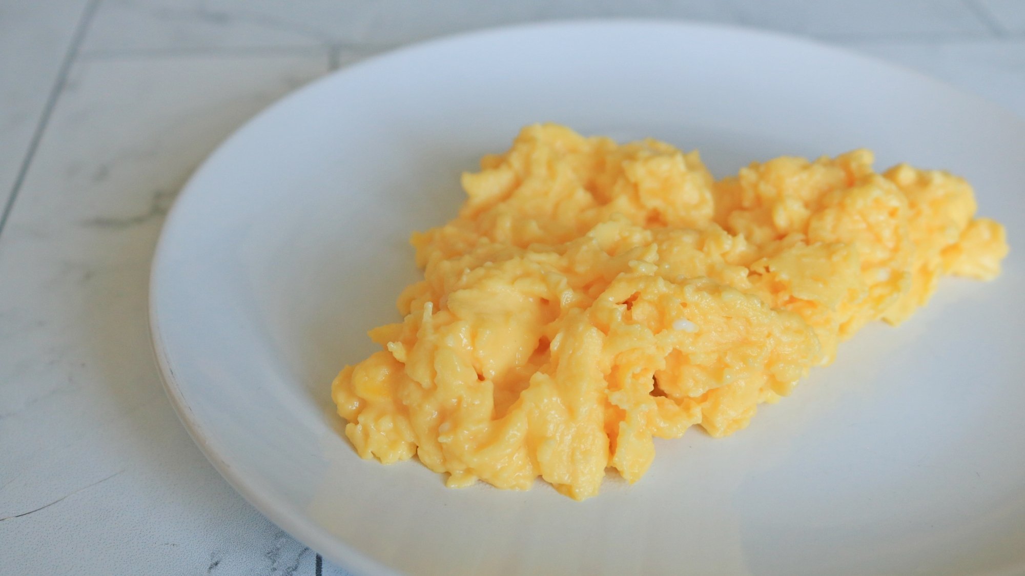 Scrambled eggs on a white plate.
