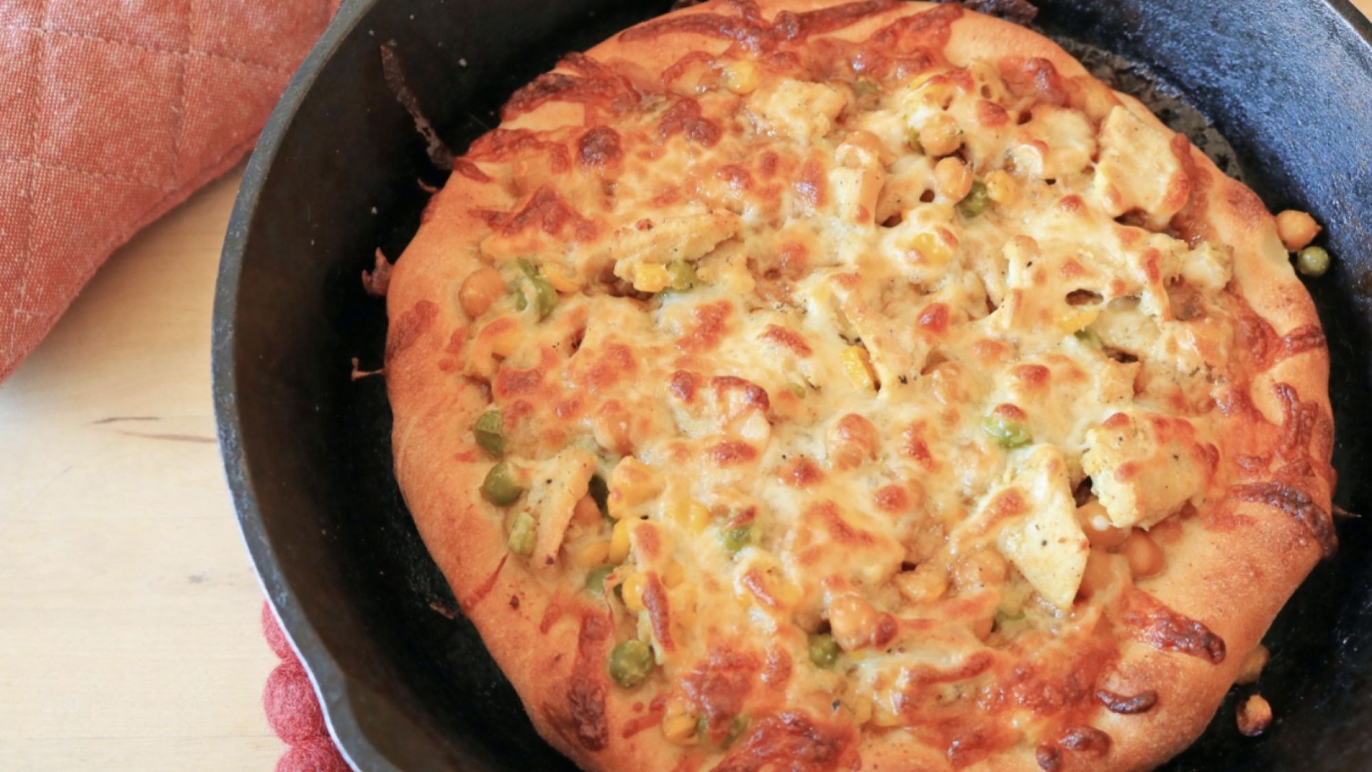 A pizza in a cast iron skillet.