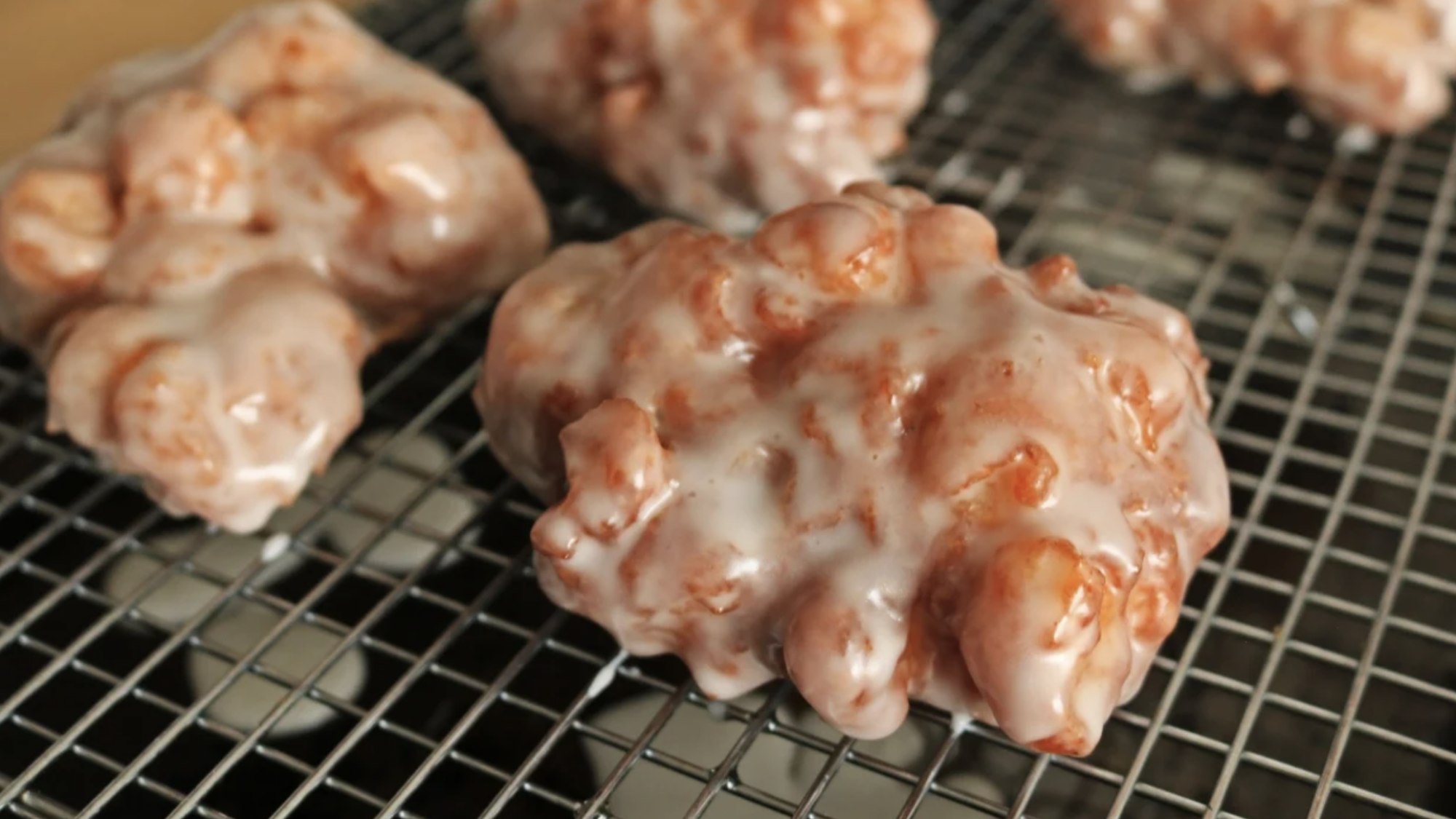 Apple fritters on a wire cooling rack.