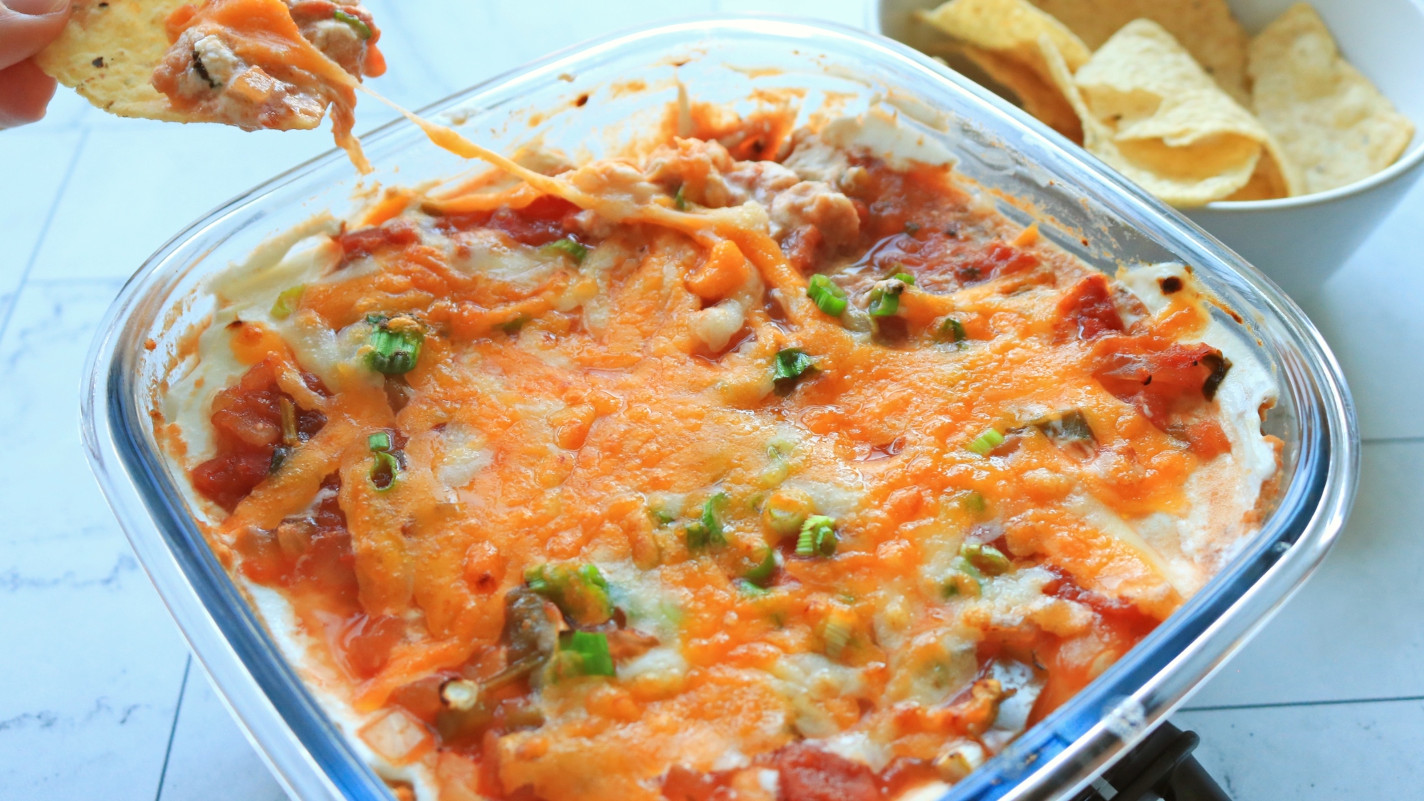 A chip dipping into a seven-layer dip.