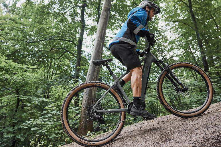 Lidl Crivit Peak 709 electric mountain bike being ridden by man along trail.