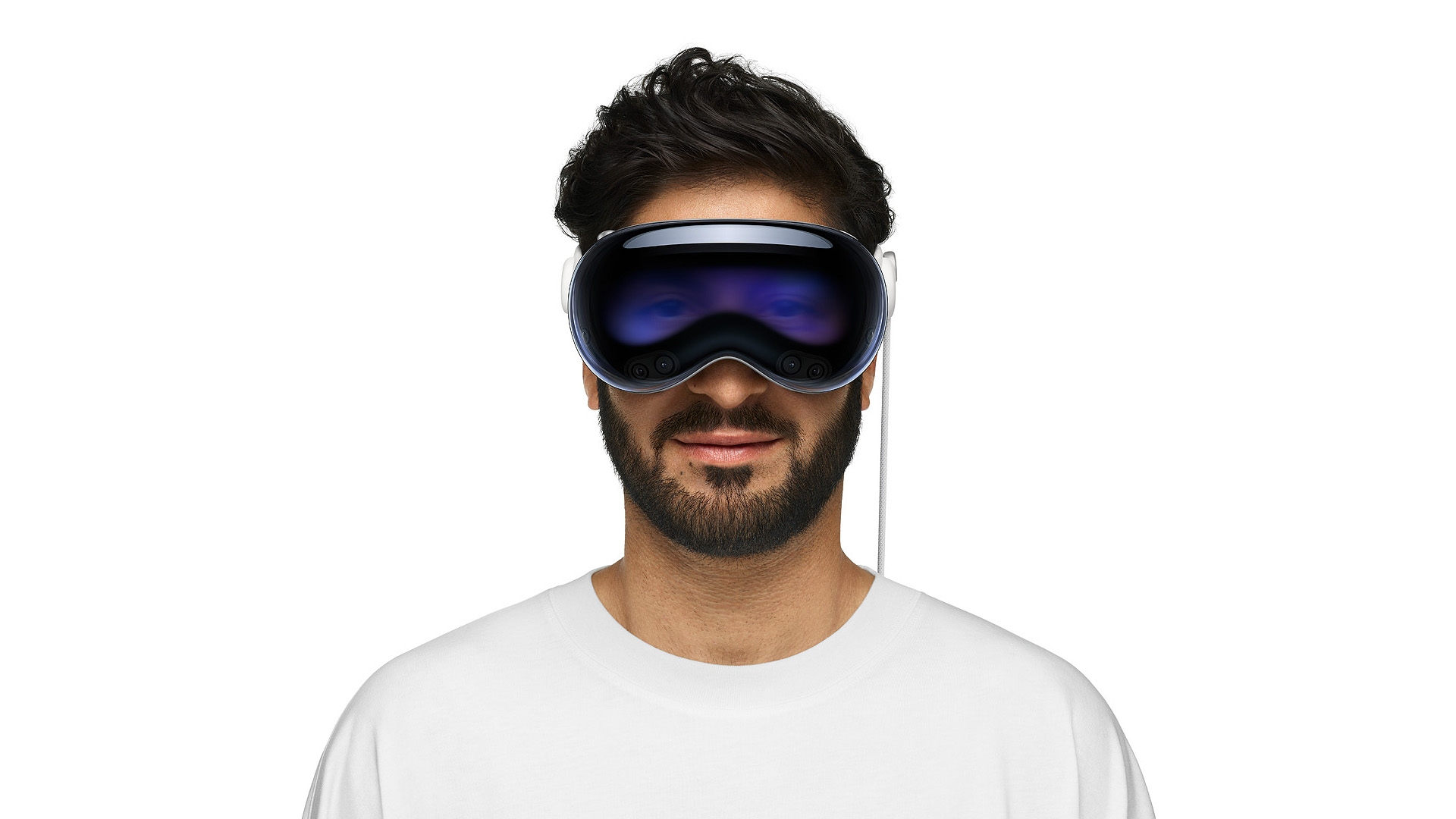 Man in white T-shirt wearing an Apple Vision Pro. We see his eyes on the front display.
