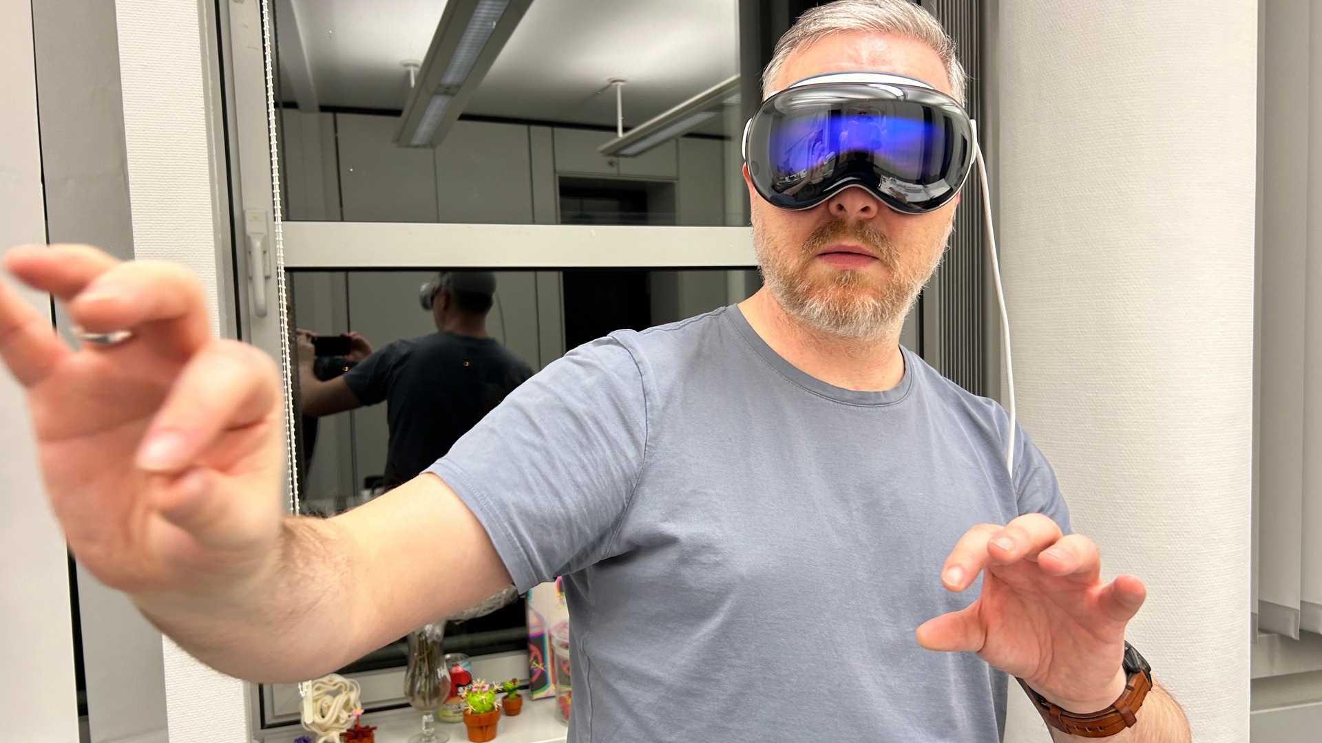 Man wears Apple Vision Pro and operates virtual interaction surfaces with his hands