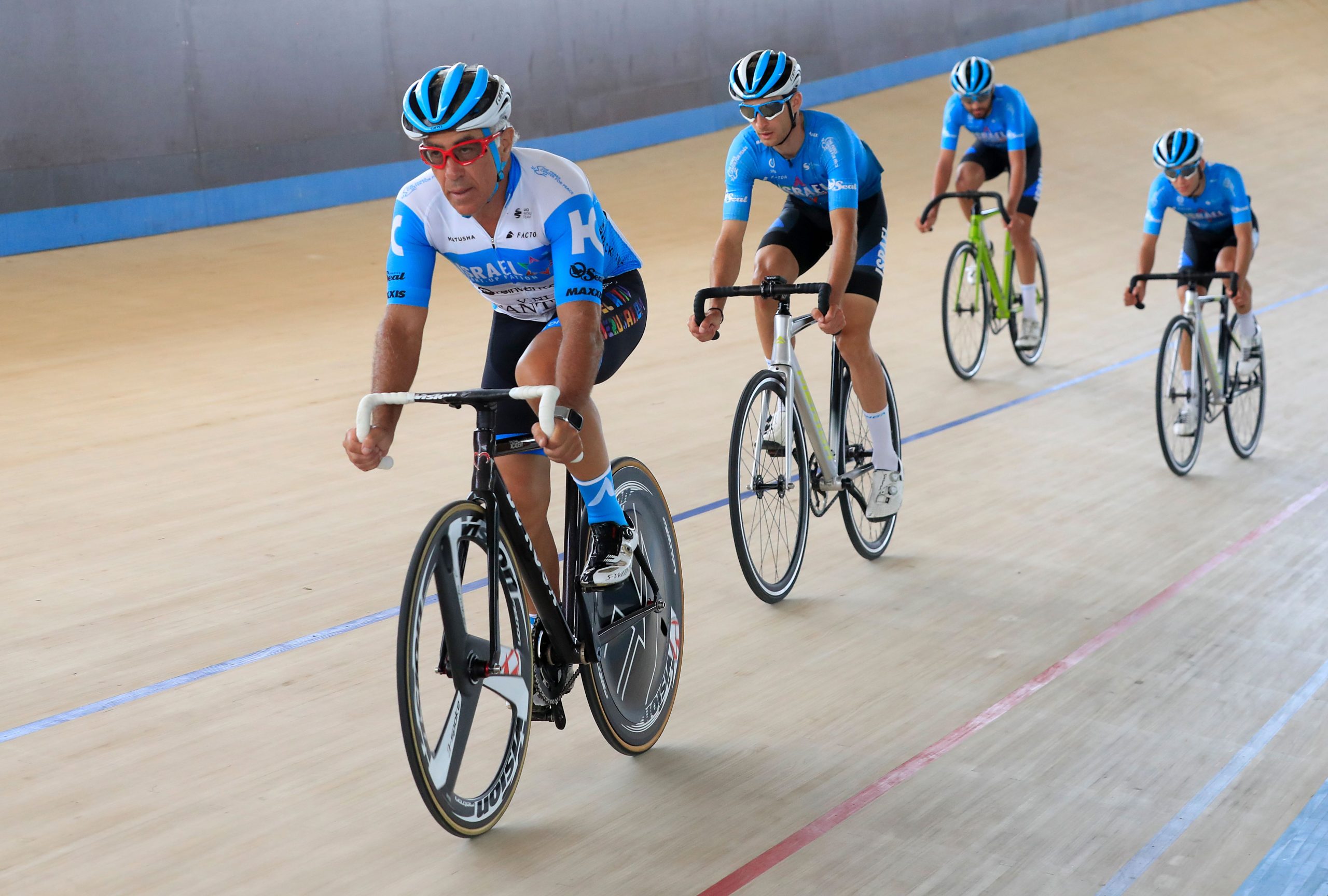 Sylvan Adams (left) rides in velodrome.