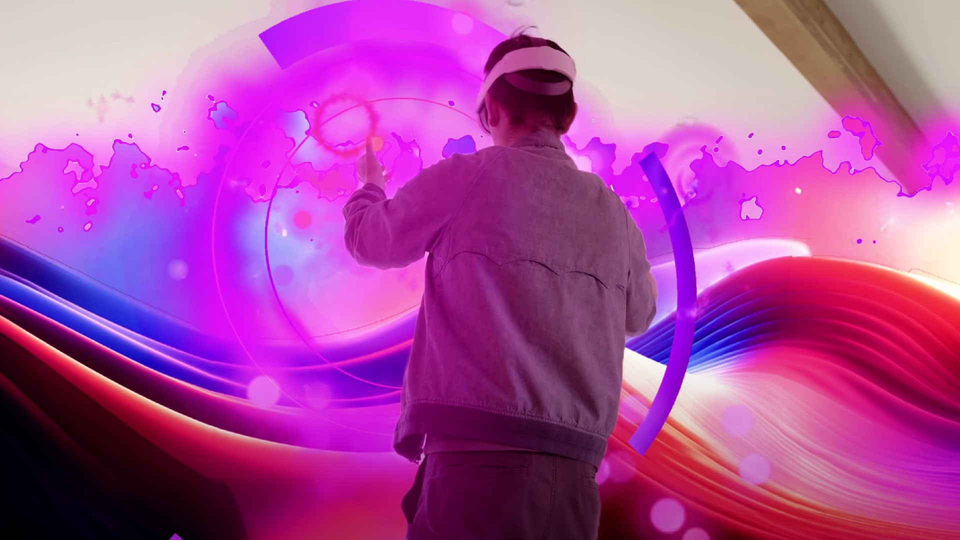 A man with a VR headset stands in a pink mixed reality environment.