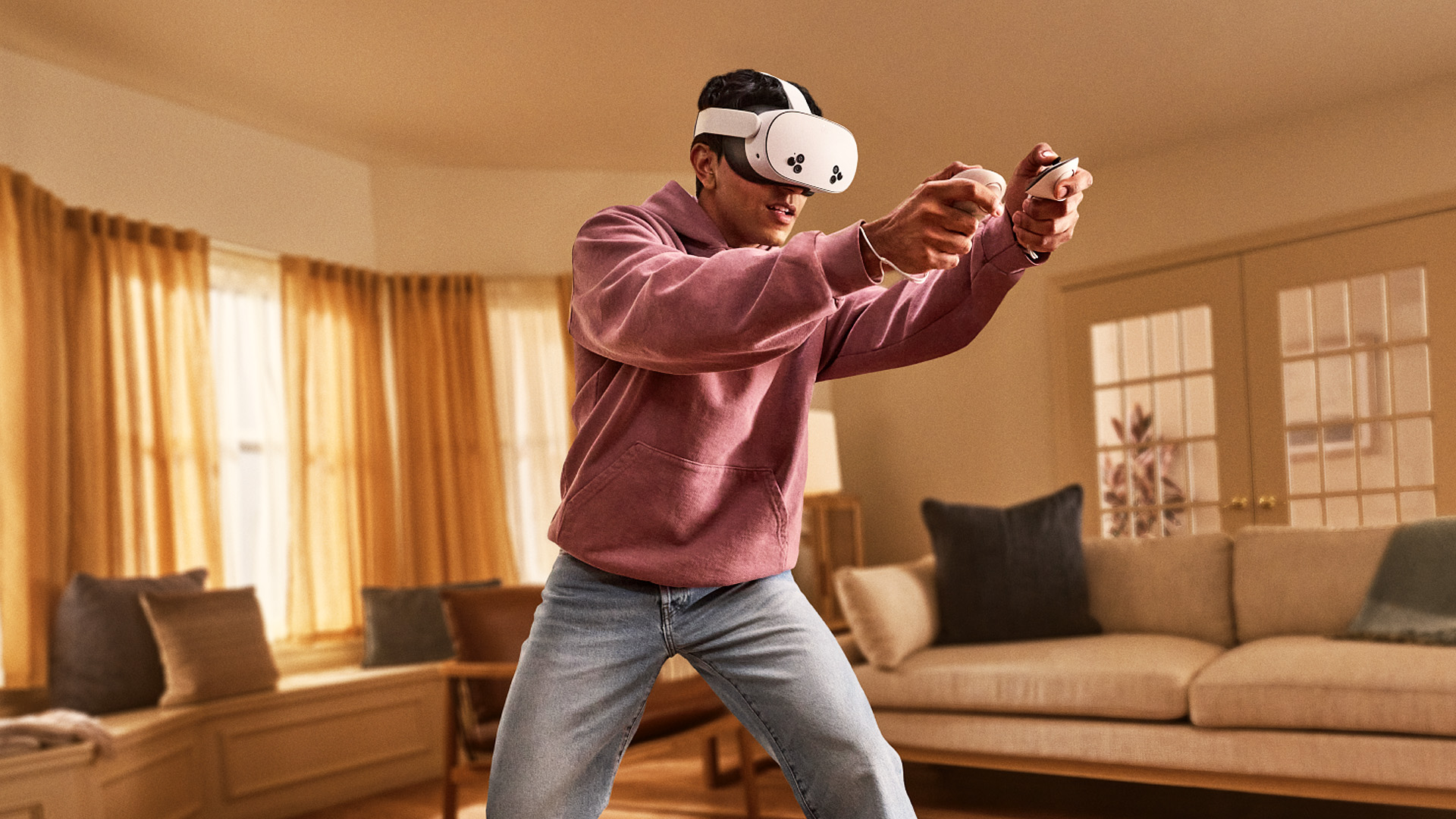 Man with VR headset and controllers actively playing a video game in the living room.